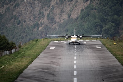 白天灰色沥青路面上的白色和黄色飞机